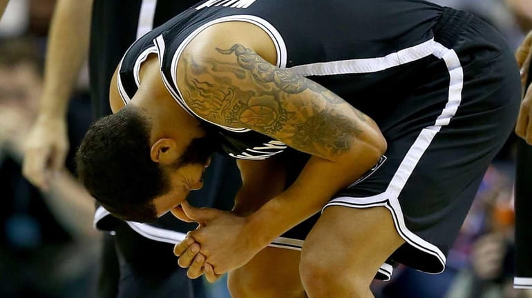 Deron Williams reacts after an injury in the first half...