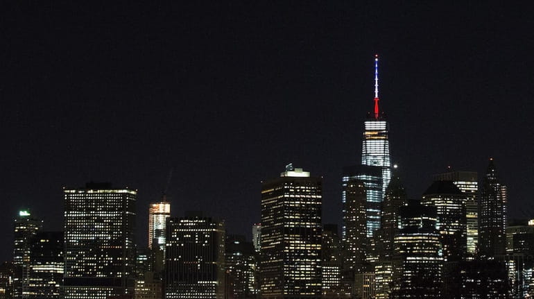 One World Trade Center's spire is shown lit in the...