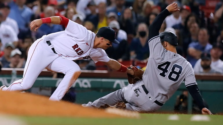 The Red Sox's Bobby Dalbec catches the Yankees' Anthony Rizzo trying...