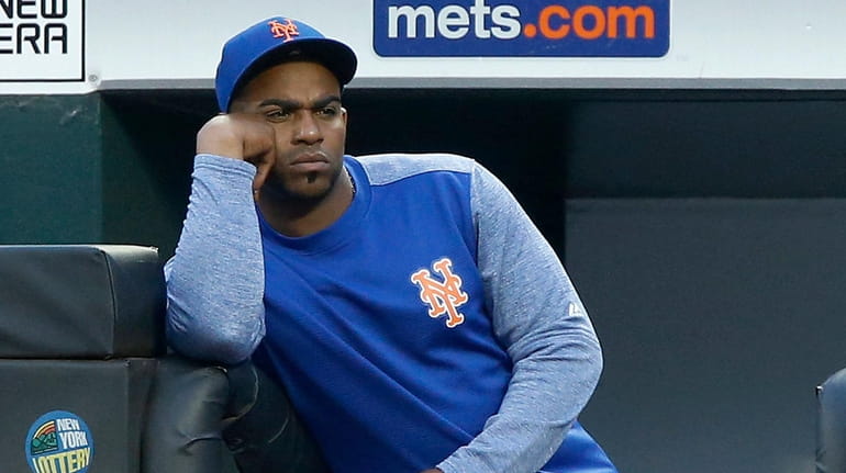 Yoenis Cespedes of the Mets looks on from the dugout...