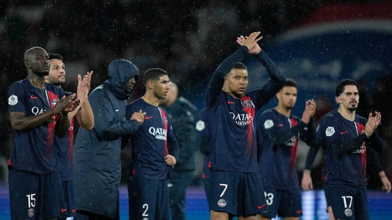 PSG's Kylian Mbappe, center, reacts with his teammates after the...