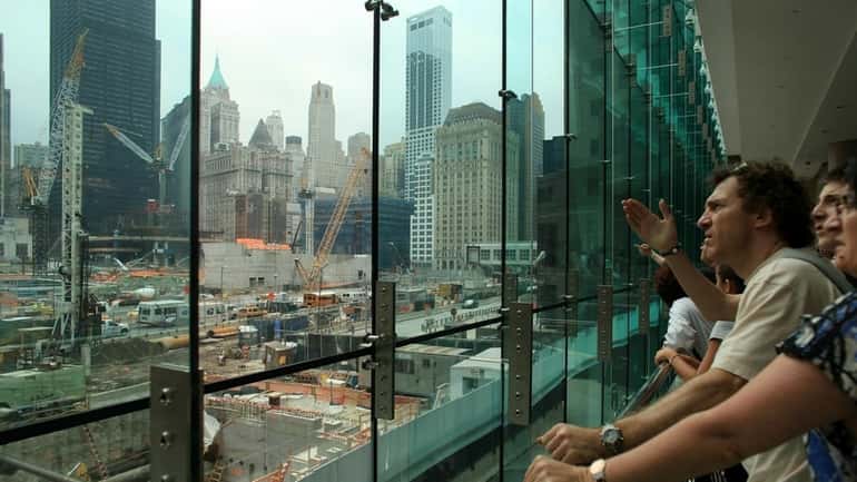 People watch construction at The World Trade Center site in...