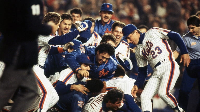 Mets teammates pile onto each other to celebrate their World...