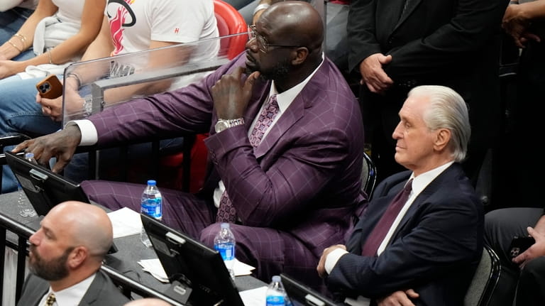 Miami Heat president Pat Riley sits with former player Shaquille...