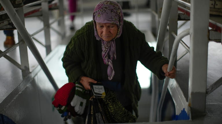 An old woman sells winter clothes accessories in a ferry...