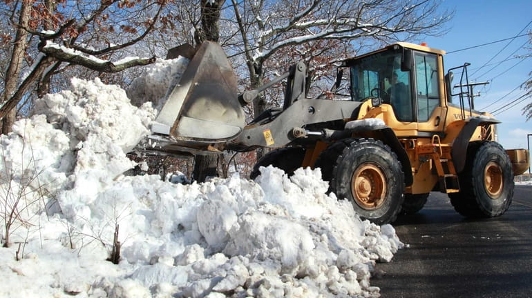 A Town of Brookhaven crew removes snow from the shoulder...