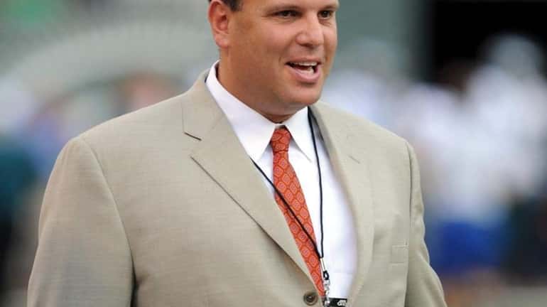 New York Jets general manager Mike Tannenbaum watches pre-game warmups...