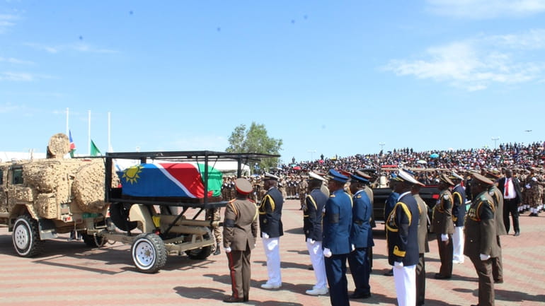 Mourners follow the flag-draped coffin of the late Namibian President...