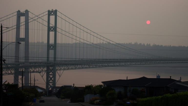 The sun sets through smoky air behind the Narrows Bridge...