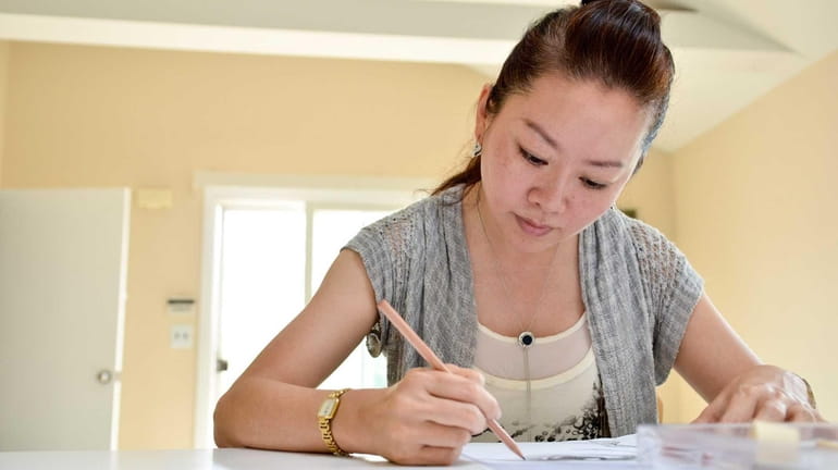 Vivian Chen of Amityville works on a new drawing she...