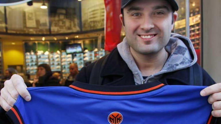 Basketball fan Mike Komarinetz holds up a new New York...