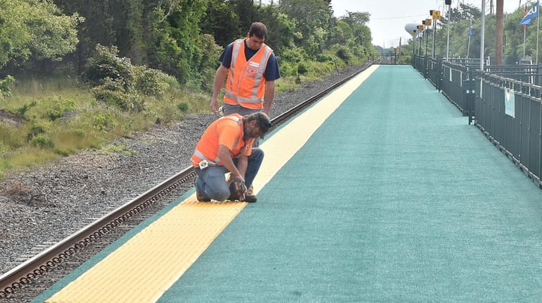 Workers get the temporary LIRR Shinnecock Hills Station ready on...
