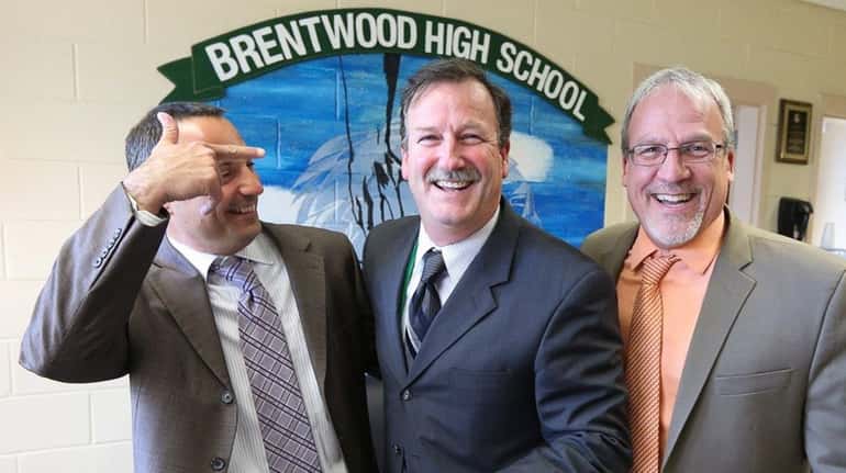 Brentwood High School Principal Richard Loeschner, center, is congratulated by...