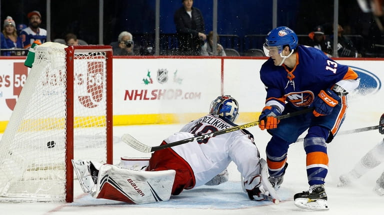 Mathew Barzal #13 of the New York Islanders scores on...