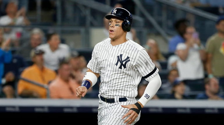 Aaron Judge of the Yankees scores a run in the seventh inning...
