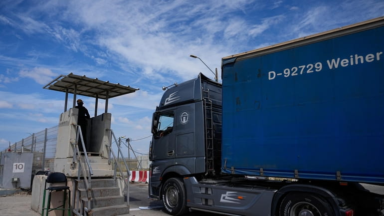 A truck carrying humanitarian aid for the Gaza Strip passes...