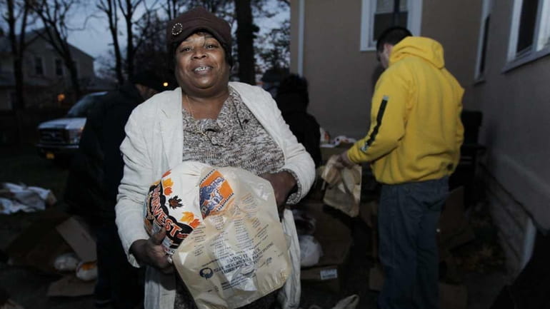 Organizer and director Joanna Richards bags a Thanksgiving turkey for...