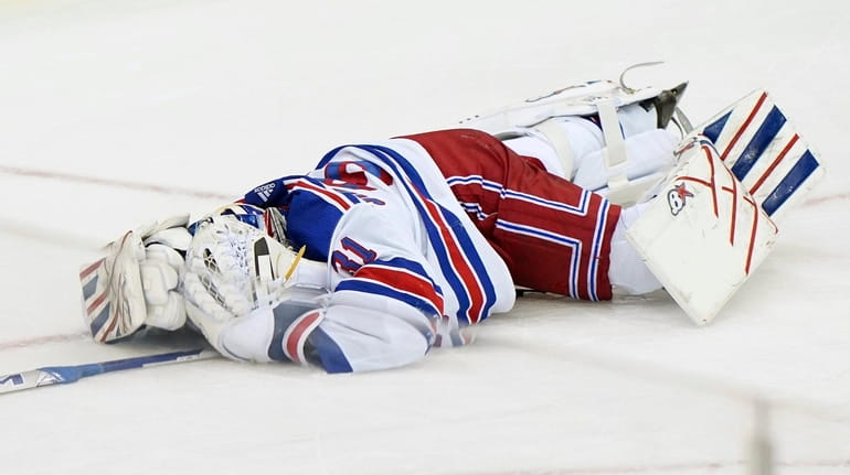 Rangers goaltender Igor Shesterkin lies on the ice after suffering an...