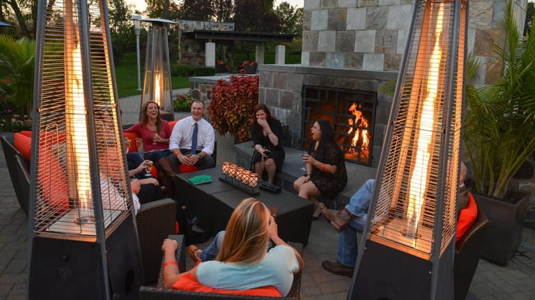 Guests gather to sip drinks and socialize by the outdoor...