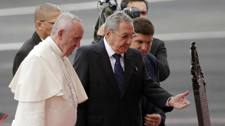 Pope Francis is escorted to a chair by Cuban President...