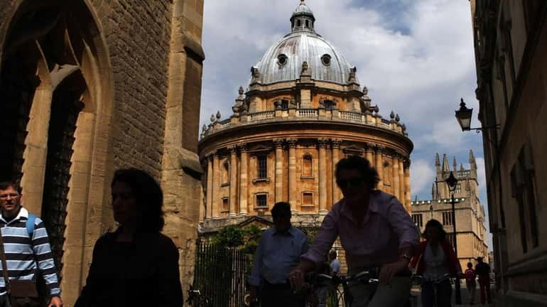 People pass the Radcliffe Camera, an 18th century Oxford University...
