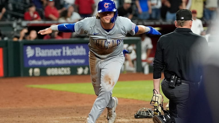 Chicago Cubs' Nico Hoerner scores on a wild pitch against...