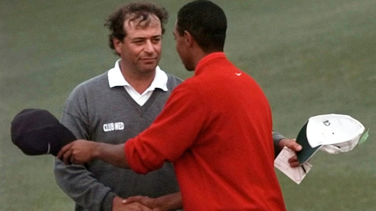 Masters champion Tiger Woods is congratulated by his playing partner...
