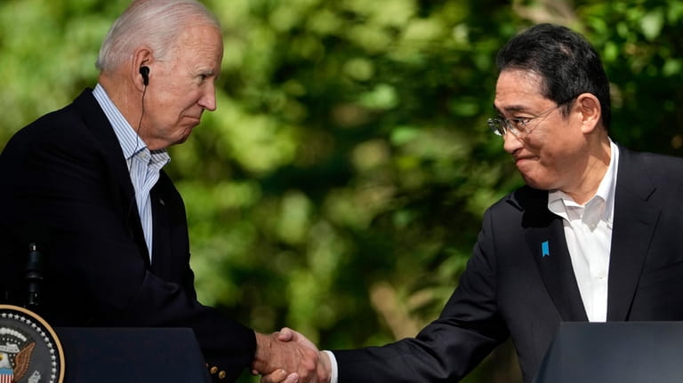U.S. President Joe Biden, left, shakes hands with Japan's Prime...