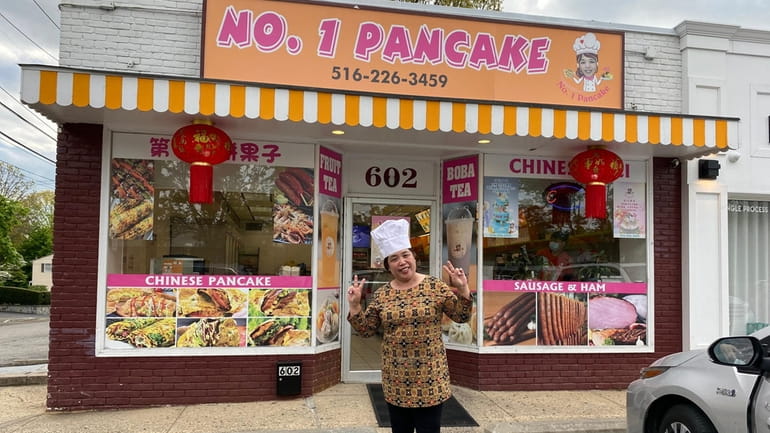 Hong Wei "Helen" Pan stands in front of her restaurant,...