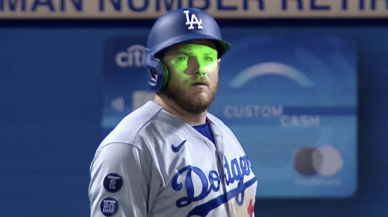 A laser beam flashed over the face of Dodgers player...