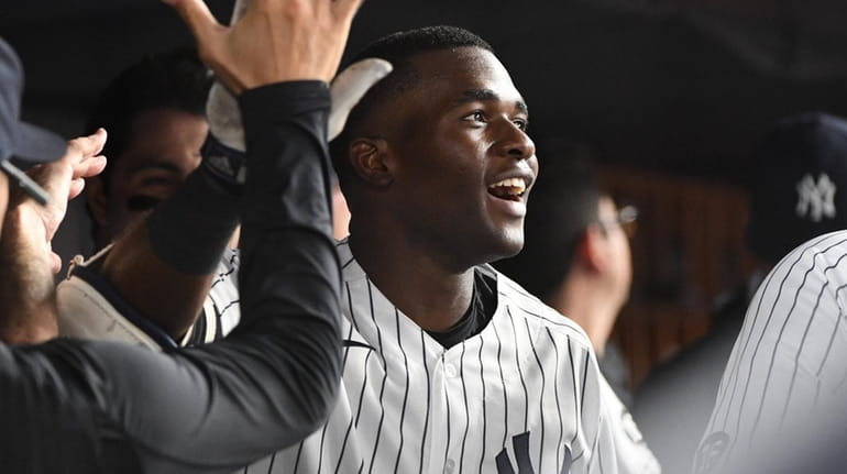 The Yankees' Estevan Florial is greeted in the dugout after...
