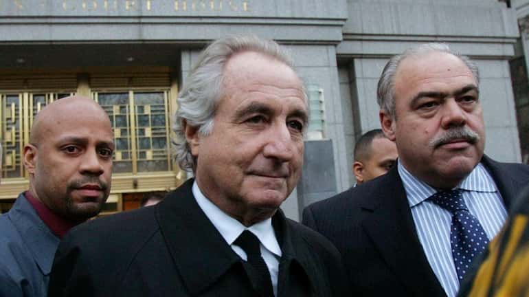 Bernard Madoff, center, walks out from federal court after a...