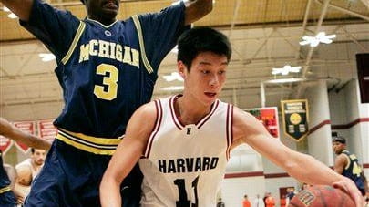 Harvard's Jeremy Lin keeps the ball away from Michigan's Manny...