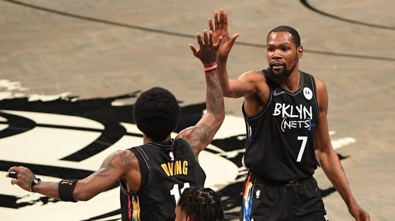 Nets forward Kevin Durant and guard Kyrie Irving high five...