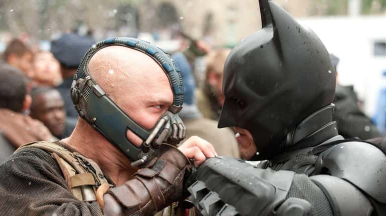 Tom Hardy as Bane and Christian Bale as Batman face...