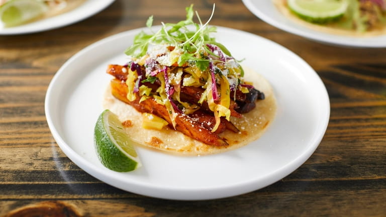 A roasted rainbow carrot taco with al pastor sauce, curtido...