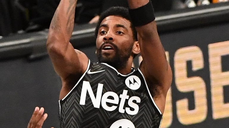 Nets guard Kyrie Irving shoots over Celtics guard Jaylen Brown...