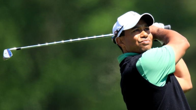 Tiger Woods watches his tee shot on the 12th hole...