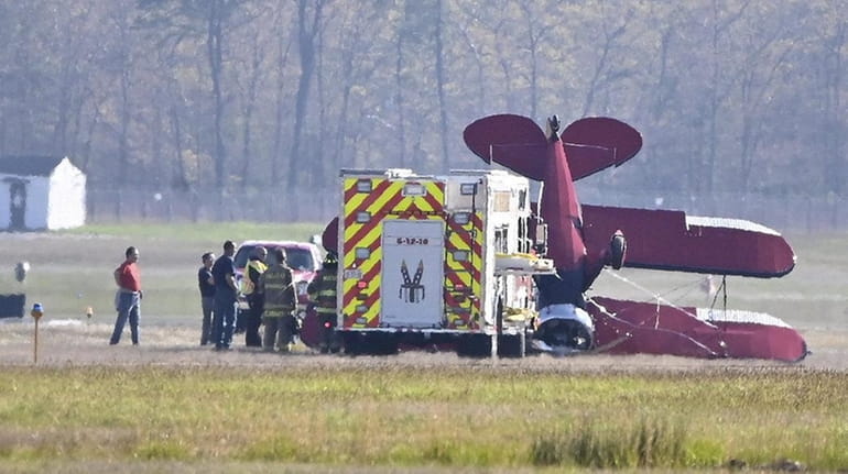 A small biplane flipped over on a runway at Brookhaven Calabro...