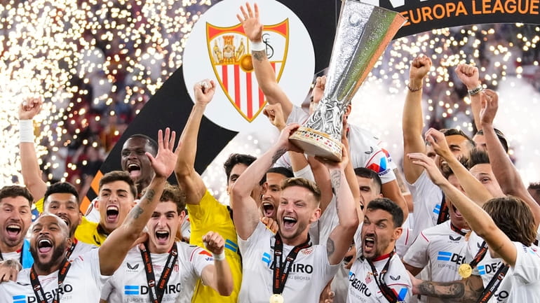 Sevilla's team captain Ivan Rakitic lifts the trophy after winning...