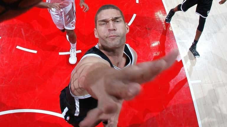 Brook Lopez of the Brooklyn Nets attempts a block against...
