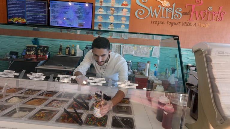 Nick Vitolo creates a frozen yogurt sundae at Swirls and Twirls...