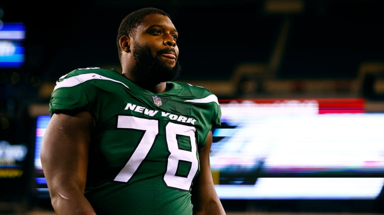 New York Jets guard Laken Tomlinson walks off the field after...