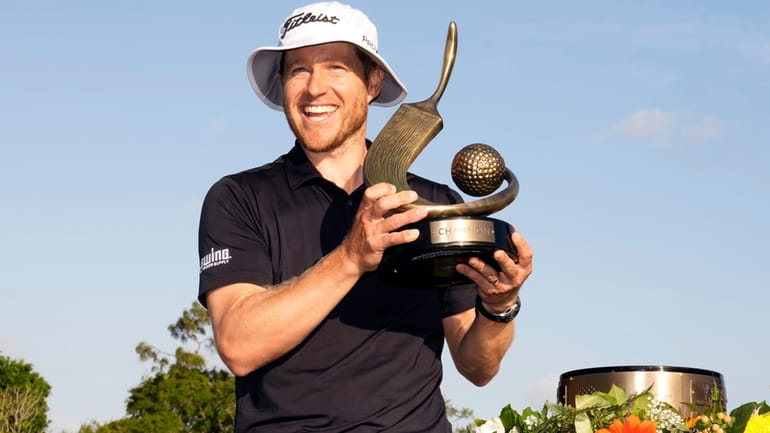 Peter Malnati holds up the trophy after winning the Valspar...