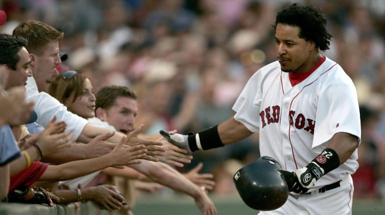 Boston Red Sox batter Manny Ramirez touches the hands of...