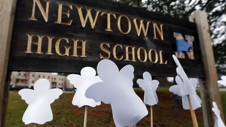 Angel cutouts are displayed outside Newtown High School in Newtown,...