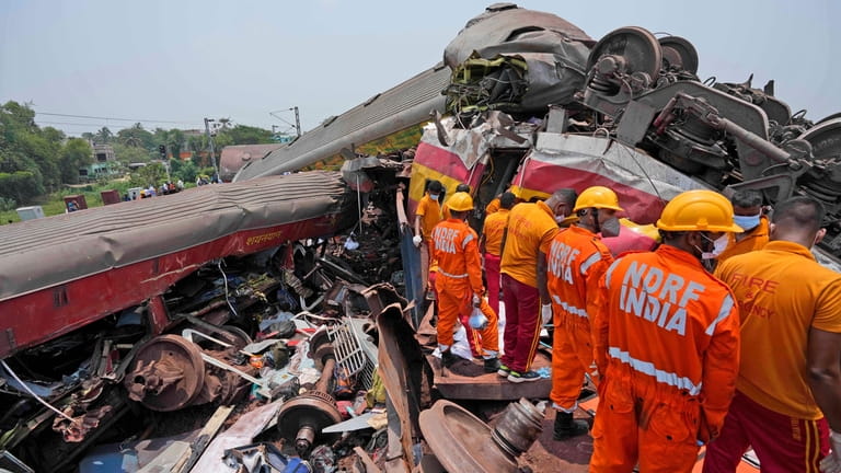 Rescuers work at the site of passenger trains that derailed...