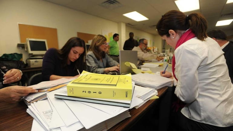 Workers examine individual affidavit ballots at the Nassau County Board...