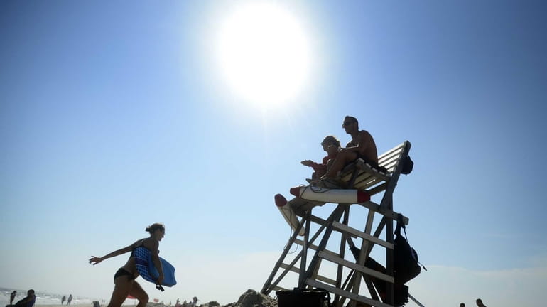 Lifeguards Kristie Hirten and Carl Nowicki sit atop their lifeguard...