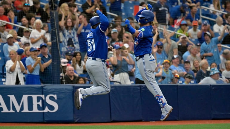 Toronto Blue Jays' Justin Turner, right, celebrates with third base...